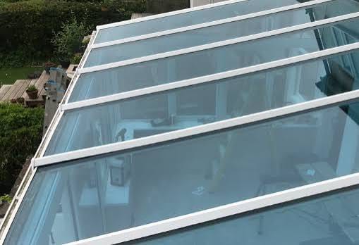 Panel kaca tempered pada rangka kanopi putih, dilihat dari atas